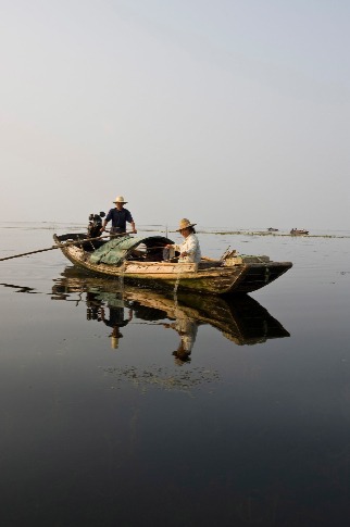  Chinese fisherfolk fishing from traditional wooden boat on Lake Hong 