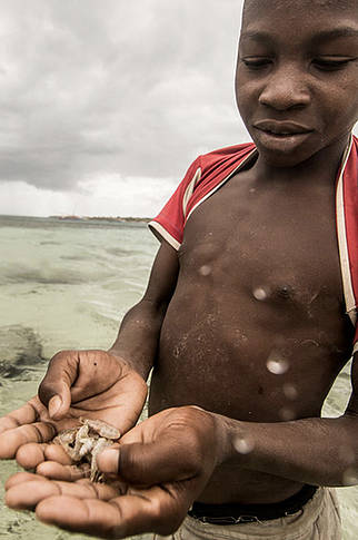  Boy uses prawns to line fish, Nuarra, Mozambique. Primeiras e Segundas 